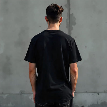 Person wearing a black t-shirt against a gray concrete wall