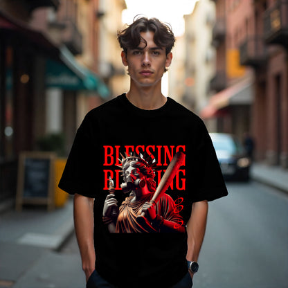 Person wearing a black t-shirt with a graphic design and text on a city street.